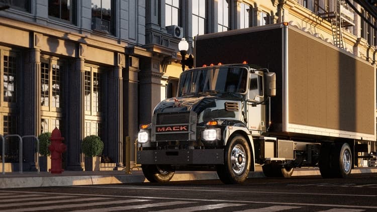Mack MD electric truck driving down a city street.
