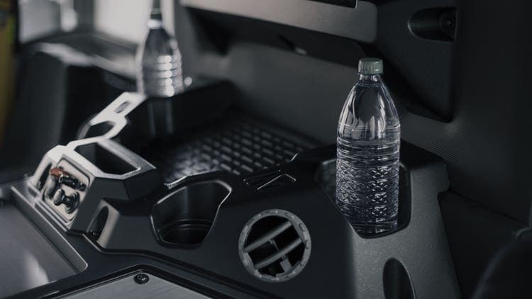 Close-up of expanded storage space in a Mack LR Series truck cab with cup holders