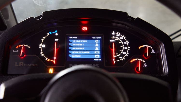 Digital dashboard display in a Mack LR Electric truck, showing vehicle speed, battery status, air pressure, and other key metrics