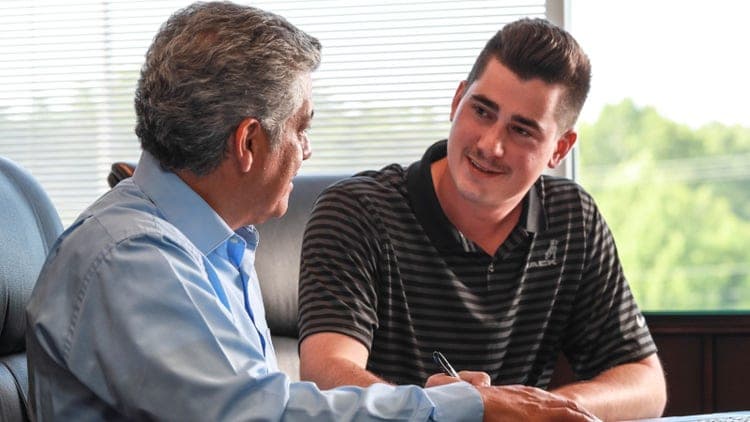 Two men discussing flexible financing terms for Mack trucks